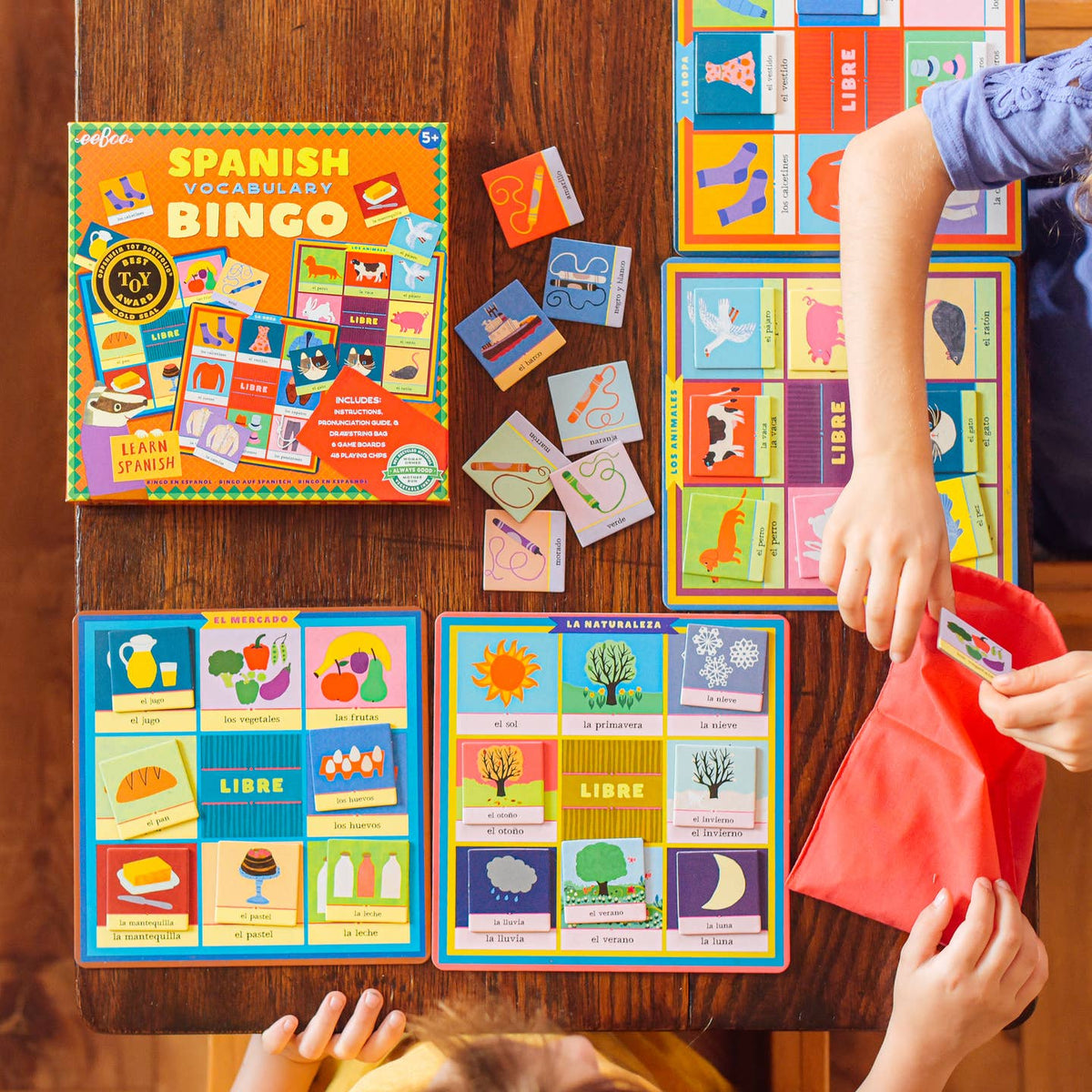 Children playing Spanish Vocabulary Bingo game on a wooden table