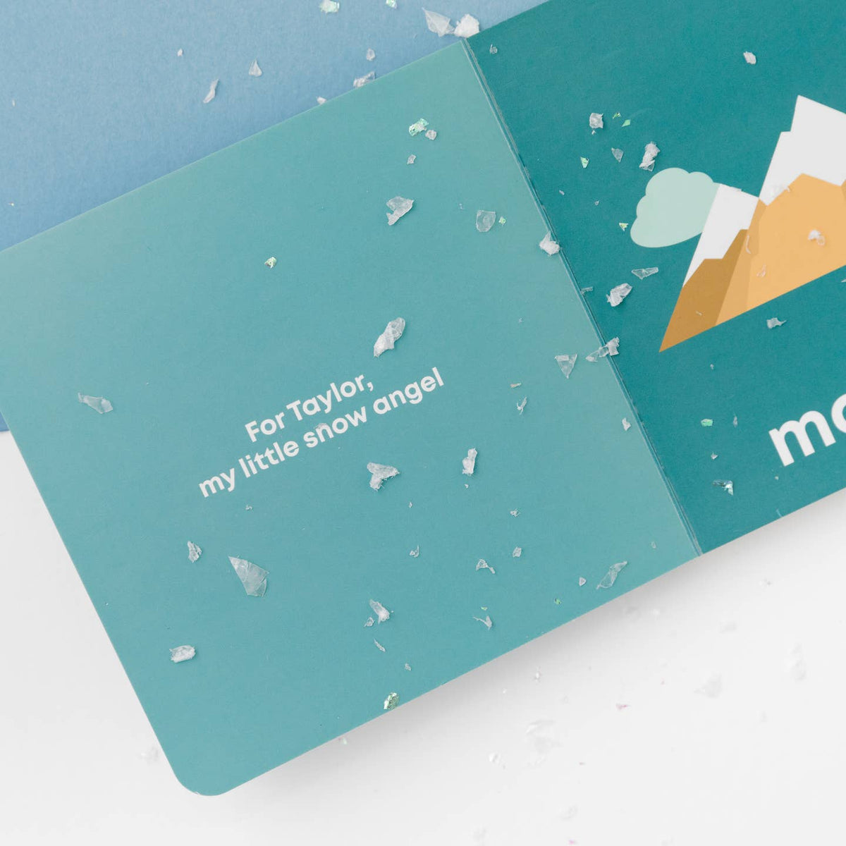 Teal card with snowflake pattern and text, featuring a mountain illustration on a light blue background.