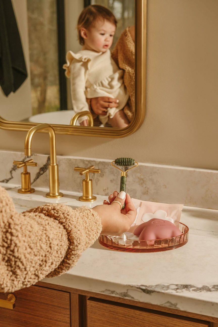 Person washing hands with soap in a bathroom, child reflected in mirror