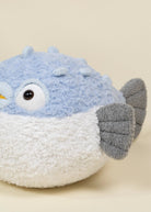 Plush toy resembling a puffer fish with blue and white body.