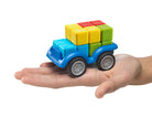 Colorful toy truck with building block cargo on a hand against a white background