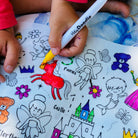Child coloring a fairy-themed coloring book with a 'HeidiDoodle' marker.