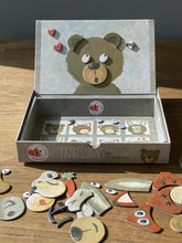 Children's craft kit with bear-themed cardboard pieces on a wooden surface