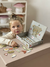 Child playing with a toy kitchen set on a pink surface