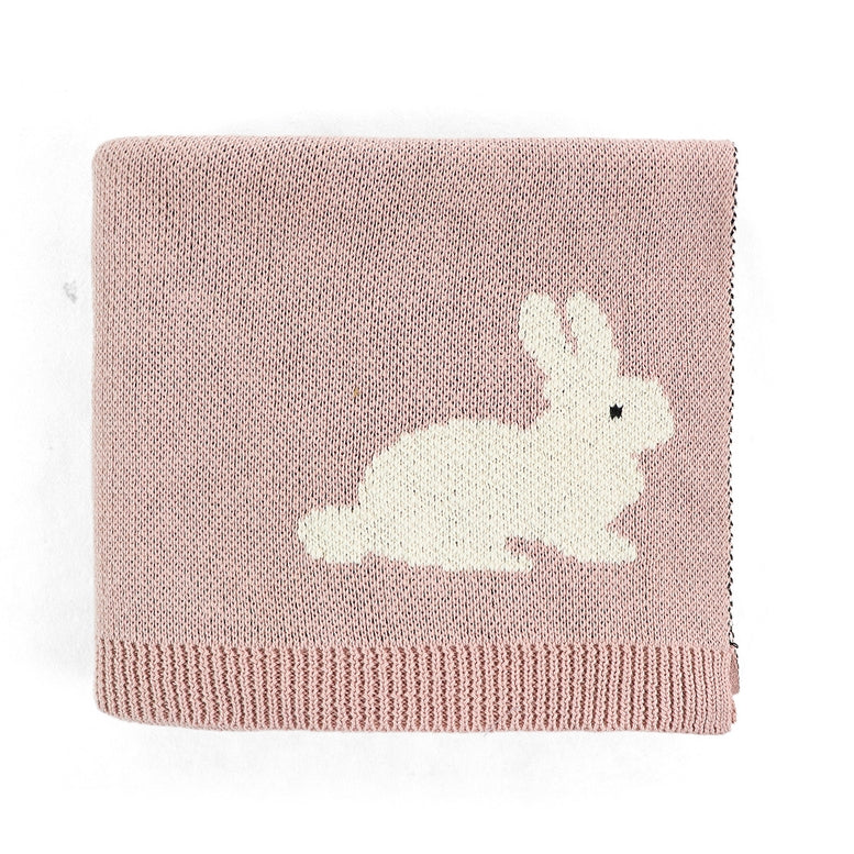 A square knitted baby blanket in dusty pink with a white rabbit motif and a ribbed hem, shown on a plain white background.