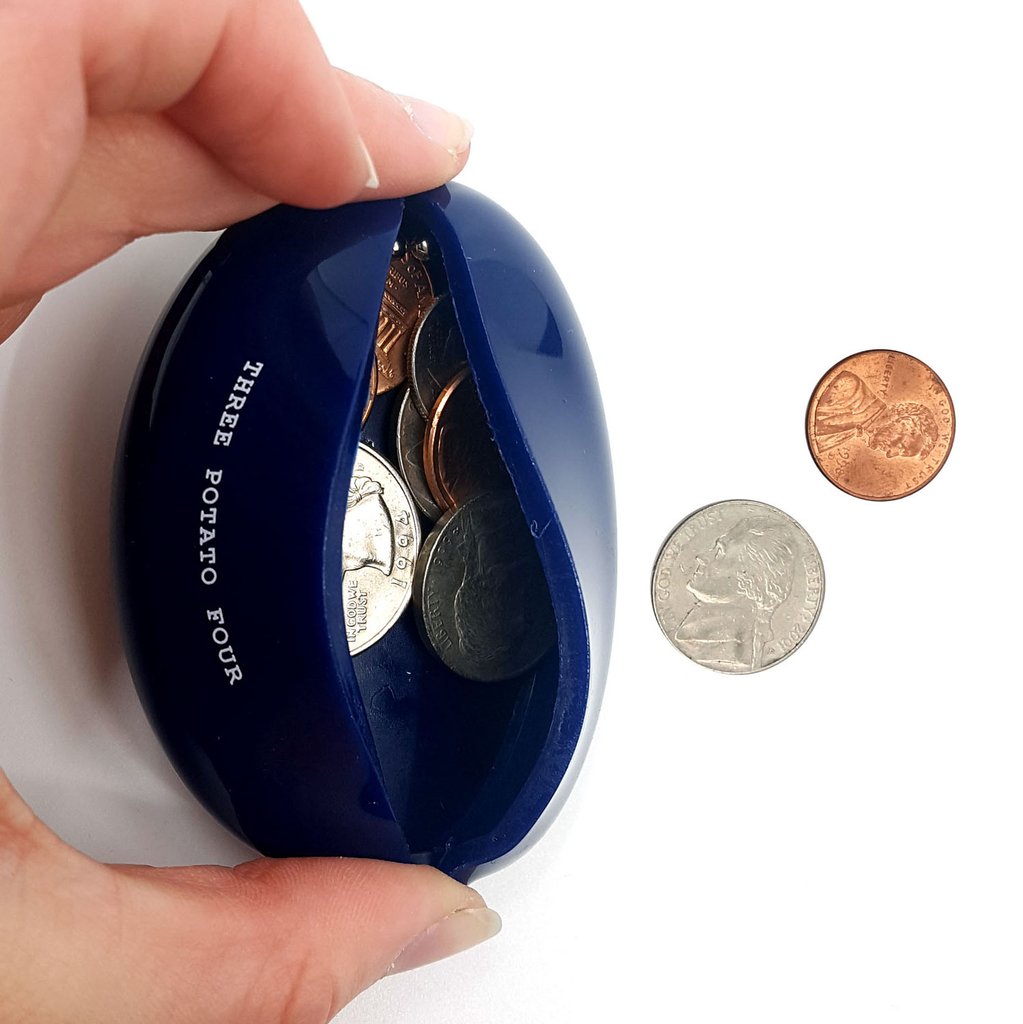 Blue coin bank with coins and a hand holding it on a white background