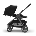A stroller in a monochrome black and dark gray colorway, shown from a side profile against a clean white background.