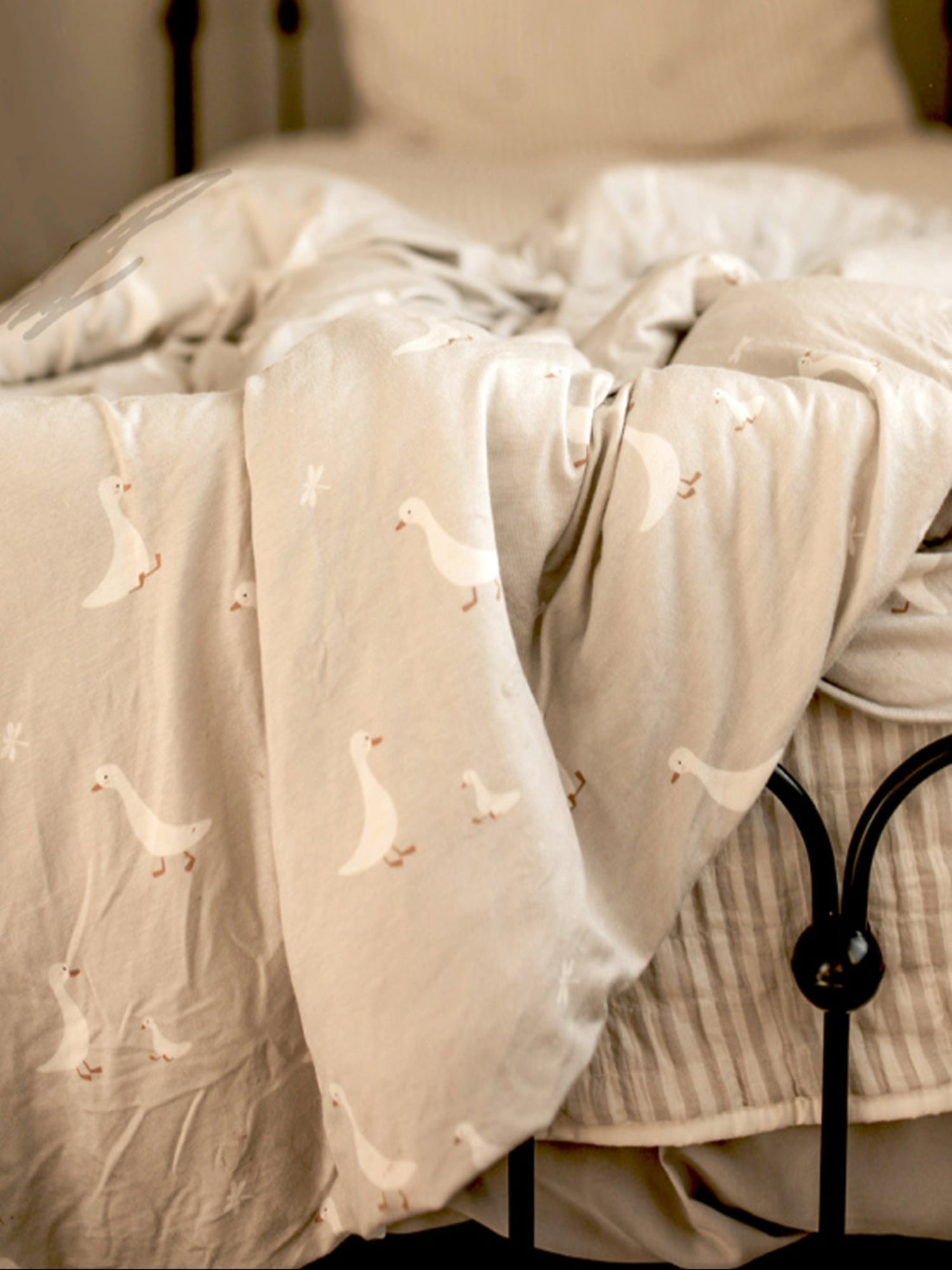 Sheer white curtain with embroidered goose patterns on a window.