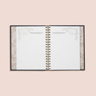 Open planner with decorative inner cover on a light pink background