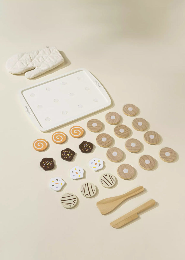 Set of cookie cutters and shaped dough on a light surface