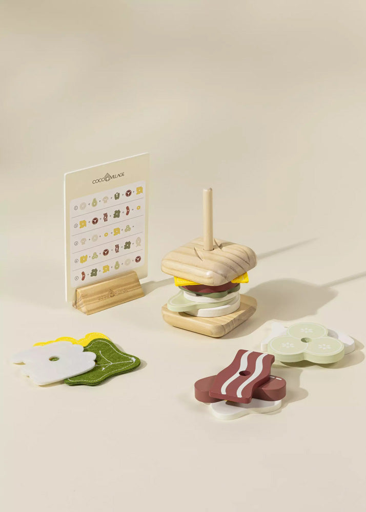 Wooden toy hamburger set with a stand on a beige background
