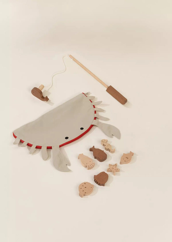 Felt fish toy with wooden rod on a beige background
