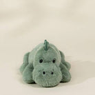 A small plush dinosaur toy in a light mint green color, photographed against a plain off-white background.