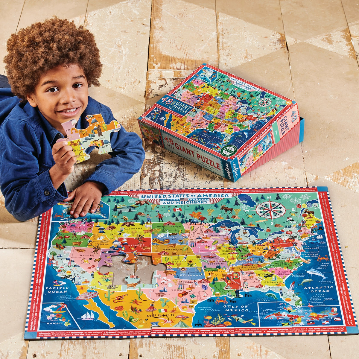 Child playing with a colorful United States puzzle on a wooden floor