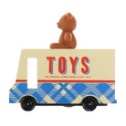 A vintage-style wooden toy delivery truck with a brown teddy bear sitting on top. The truck has a cream-colored upper body with large red and blue 'TOYS' lettering, and a blue and cream plaid pattern on the lower half.