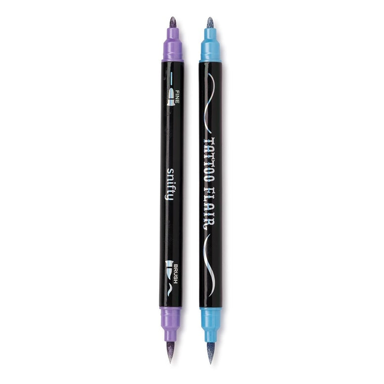 Two Tattoo Flair double-ended tattoo markers placed vertically side by side against a white background, featuring black barrels printed with "Tattoo Flair" and "Snifty" text alongside fine-tip and brush-tip icons. Each marker is capped with a different metallic shade at both ends, showing a light purple cap on the left and a bright blue cap on the right.