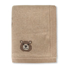 Beige knitted blanket with a bear face design on a white background
