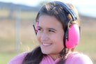 Person wearing pink ear protection in an outdoor setting