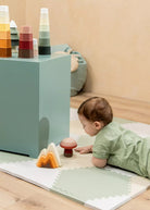 Baby playing with colorful toys on a wooden floor