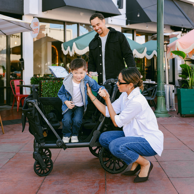 Family with a child in a stroller on a sidewalk