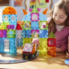 Children playing with colorful magnetic building blocks on a table.