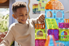 Child playing with colorful magnetic building blocks indoors