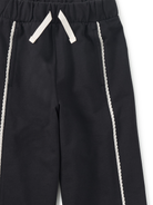 Black pants with white drawstrings and side stripes on a white background