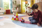Child playing with colorful building blocks on a rug in a living room.