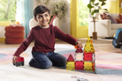 Child playing with colorful building blocks on a rug in a living room.