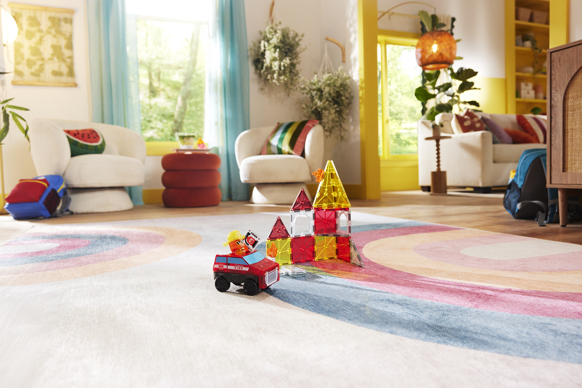 Colorful toy blocks and car on a rug in a living room with furniture and decor.