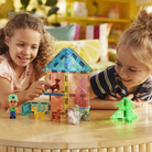 Two children playing with colorful building blocks on a wooden table.