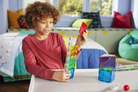 Child playing with colorful building blocks in a room with a couch and pillows.