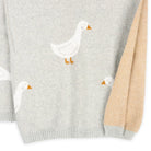 Gray sweater with white duck designs on a white background