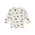A long-sleeve cream-colored top featuring an all-over print of colorful illustrated books in red, green, yellow, and brown, displayed on a clean white background.