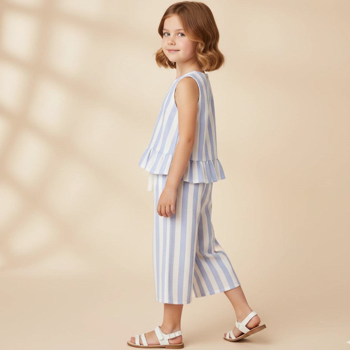 Young girl wearing a blue and white striped outfit on a beige background