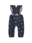 A pair of toddler girl's navy blue corduroy overall with a small pink, green, and white floral print, featuring ruffled shoulder straps and elastic cuffs.