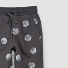 Close-up dark gray jogger pants with an all-over basketball print, featuring a drawstring waist and ribbed cuffs, shown against a plain white background.