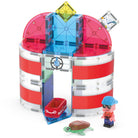 The Magna-Tiles Lighthouse Rescue set built on a white background, featuring a red-and-white striped cylindrical lighthouse structure, a red rescue raft with a character figurine, and a sea turtle figure.