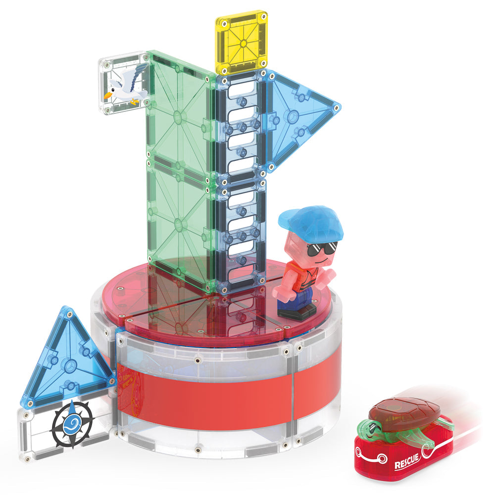 The Magna-Tiles Lighthouse Rescue set built on a white background, featuring a tall green-and-white striped tower structure on a red circular base, a character figurine, and a red rescue raft carrying a sea turtle figure.