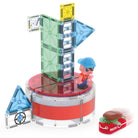 The Magna-Tiles Lighthouse Rescue set built on a white background, featuring a tall green-and-white striped tower structure on a red circular base, a character figurine, and a red rescue raft carrying a sea turtle figure.