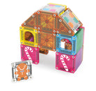 A colorful magnetic building toy set arranged to form a house-shaped structure, with a gingerbread man piece placed in front on a plain white background.