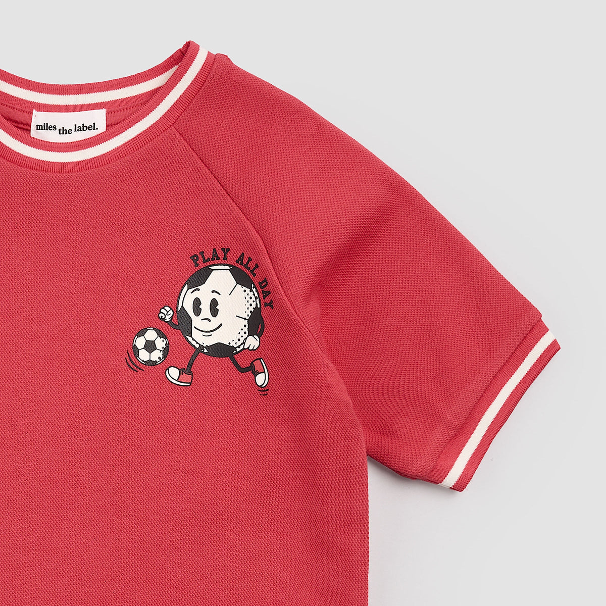 Red sweatshirt with cartoon character and text on a light gray background
