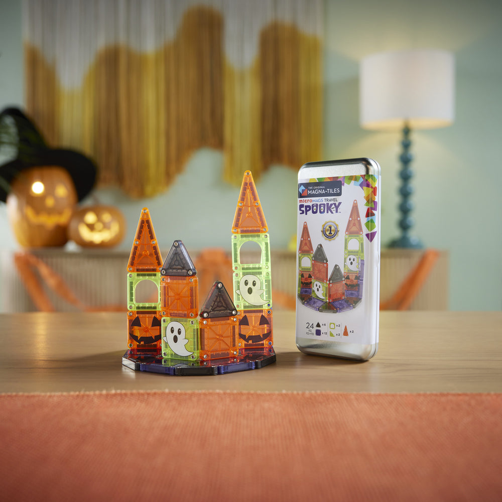 Halloween-themed magnetic building set with smartphone app on a table