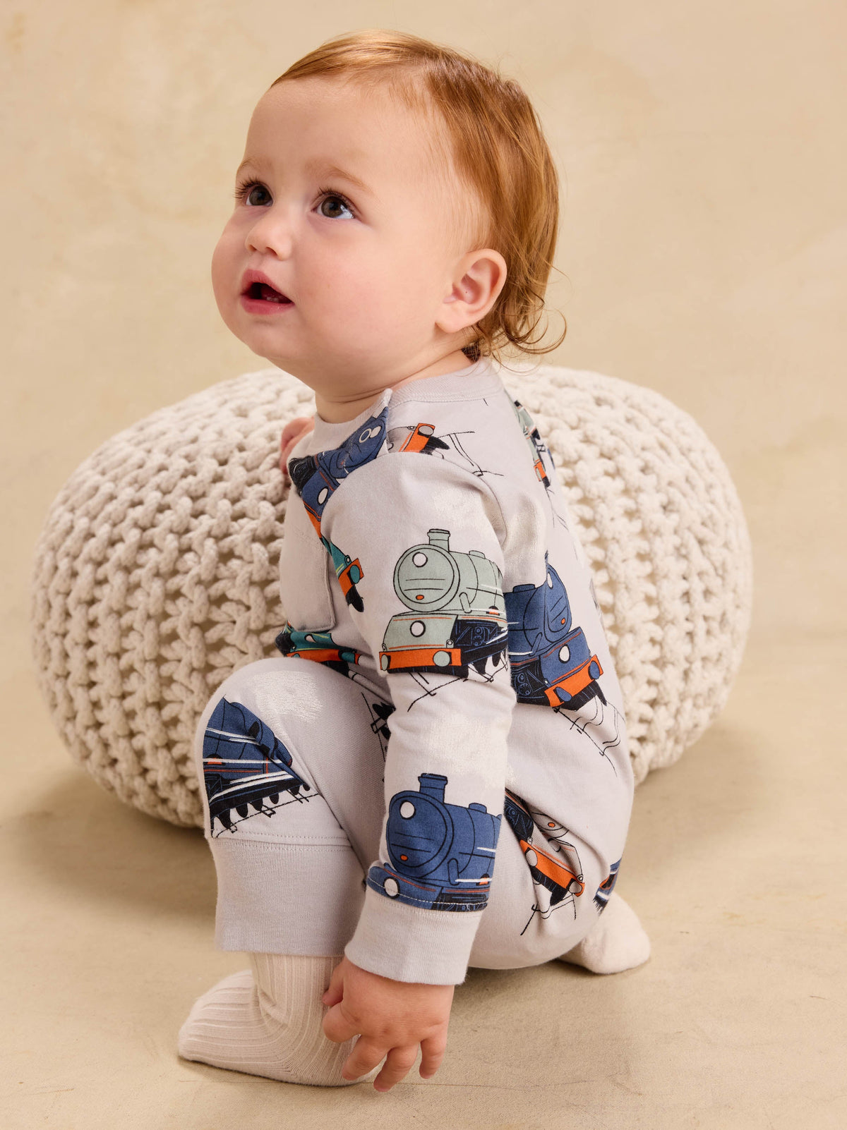 Long sleeve baby romper featuring an all-over vintage steam locomotive train print on a white background.