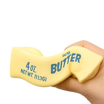 Hand holding a block of butter with text on a white background