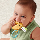 Baby holding a yellow teething toy with a smiley face