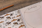 Notebook with cowboy-themed design on a wooden surface