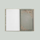 Open book with decorative cover on a light gray background