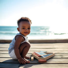 Child playing with wooden blocks on a wooden deck by the ocean