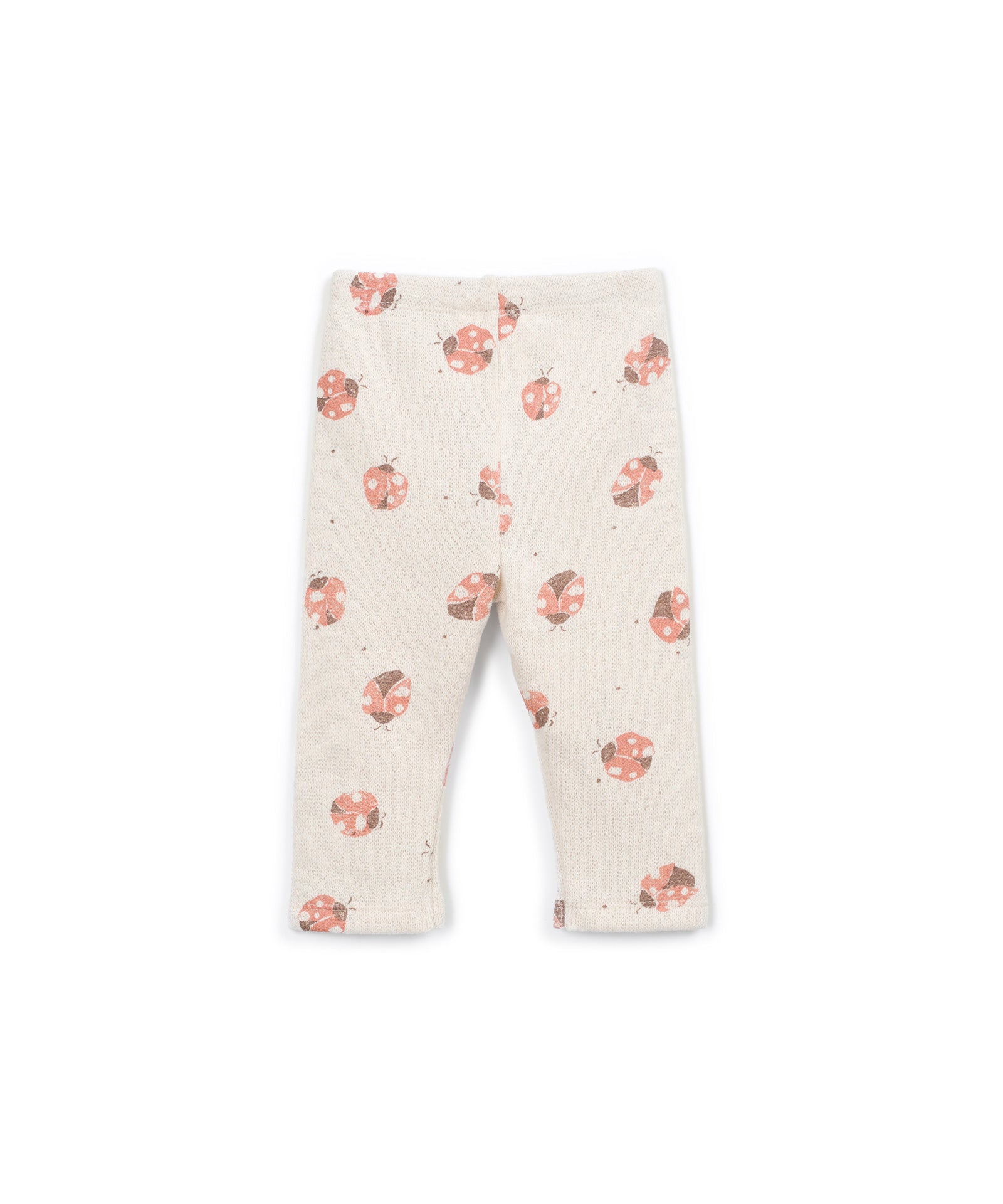 A pair of baby leggings in a warm cream color, featuring a scattered print of pink and orange ladybugs with tiny dark accents.